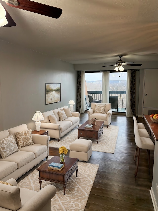 living room featuring ceiling fan and dark hardwood / wood-style floors