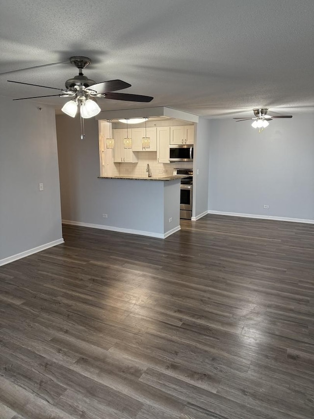 unfurnished living room with ceiling fan, sink, a textured ceiling, and dark hardwood / wood-style flooring