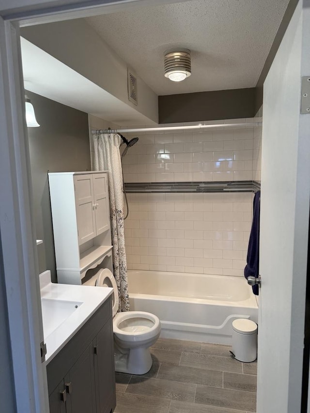 full bathroom with vanity, toilet, shower / tub combo, and a textured ceiling