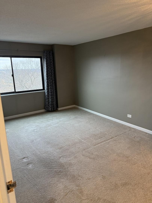 carpeted spare room with a textured ceiling