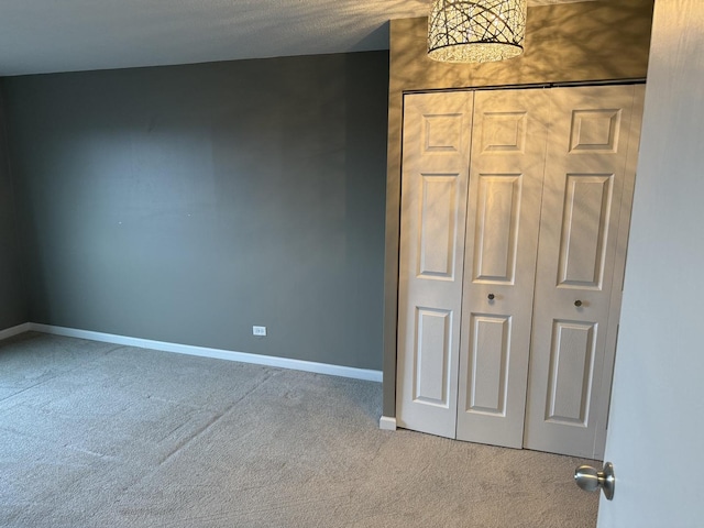 unfurnished bedroom featuring a closet and light carpet