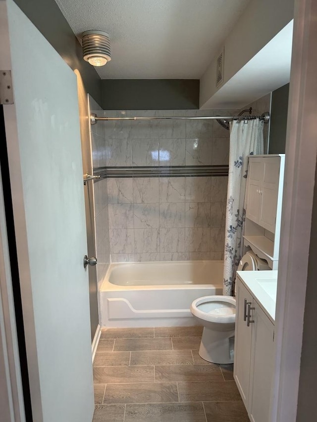 full bathroom with vanity, a textured ceiling, toilet, and shower / tub combo with curtain