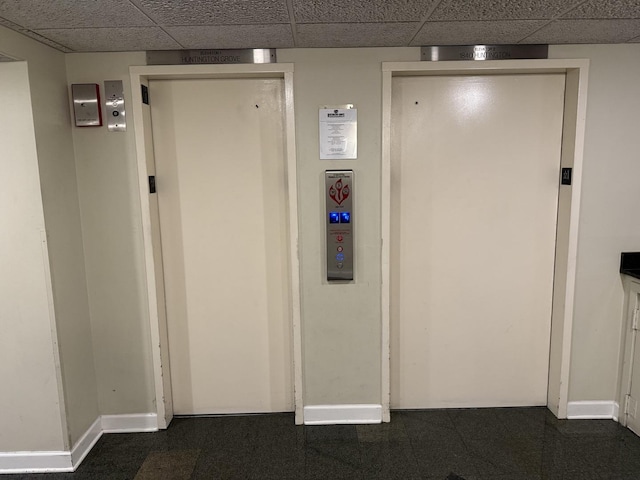 corridor featuring a drop ceiling and elevator