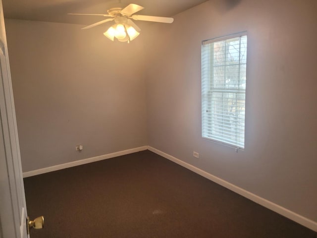 empty room with dark carpet and ceiling fan