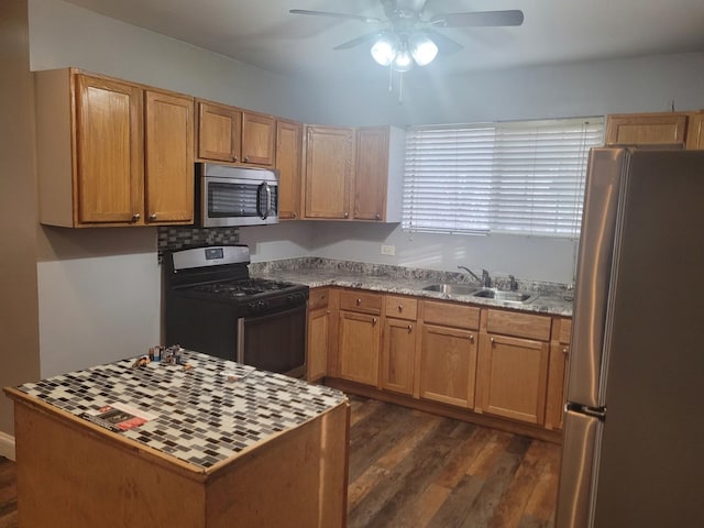 kitchen with dark wood-type flooring, sink, light stone counters, appliances with stainless steel finishes, and ceiling fan