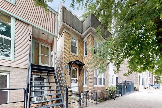 multi unit property featuring brick siding and fence