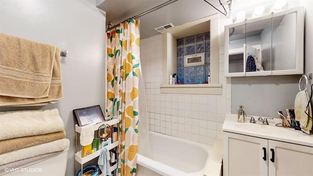 bathroom featuring shower / bathtub combination with curtain, visible vents, and vanity