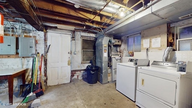 unfinished below grade area with electric panel, independent washer and dryer, visible vents, and heating unit