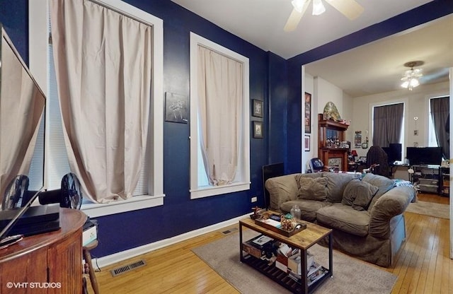 living room featuring visible vents, ceiling fan, light wood-style flooring, and baseboards