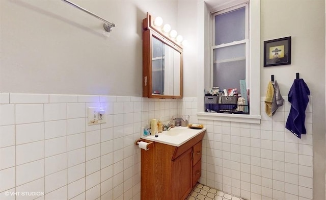 bathroom featuring tile walls, a wainscoted wall, and vanity