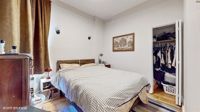 bedroom featuring visible vents, a closet, and wood finished floors