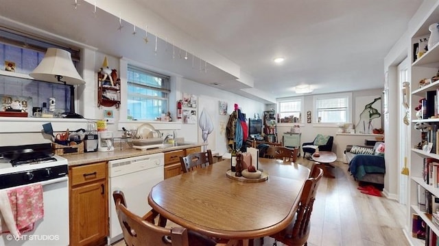 kitchen featuring white appliances, light wood-style floors, open floor plan, light countertops, and brown cabinetry