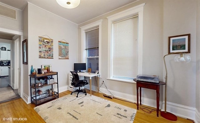 office space featuring baseboards, visible vents, and wood finished floors