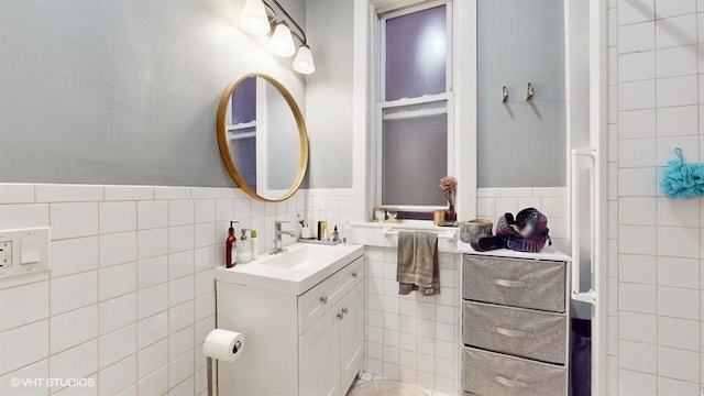 bathroom featuring a wainscoted wall, tile walls, and vanity