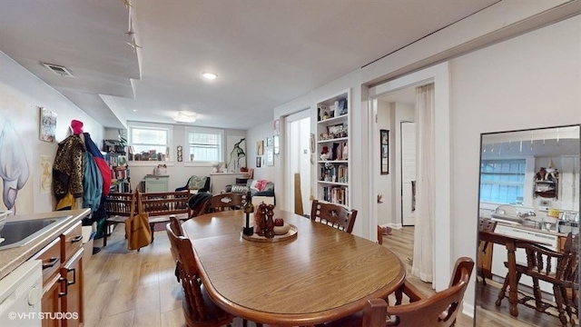 dining space with light wood-style flooring and visible vents