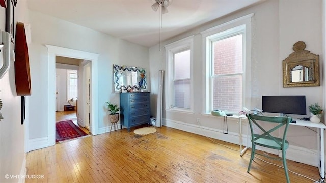 home office with light wood-style floors and baseboards