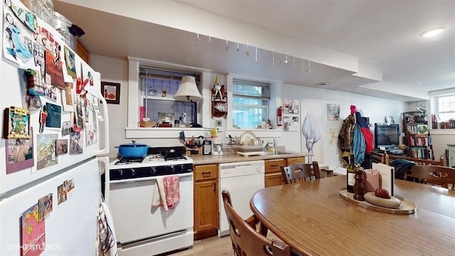 kitchen featuring white appliances, light countertops, and brown cabinetry