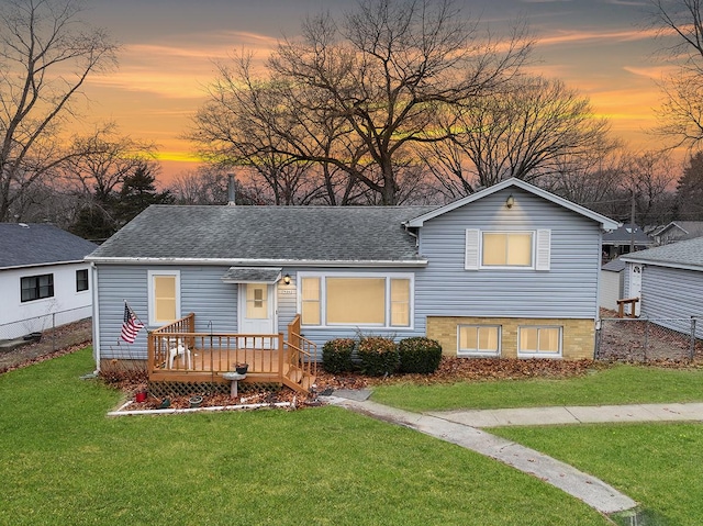 view of front of property featuring a wooden deck and a yard