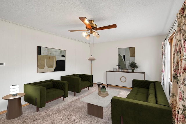 carpeted living room featuring ceiling fan and a textured ceiling