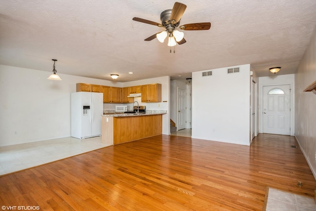 kitchen featuring pendant lighting, sink, light hardwood / wood-style floors, kitchen peninsula, and white appliances