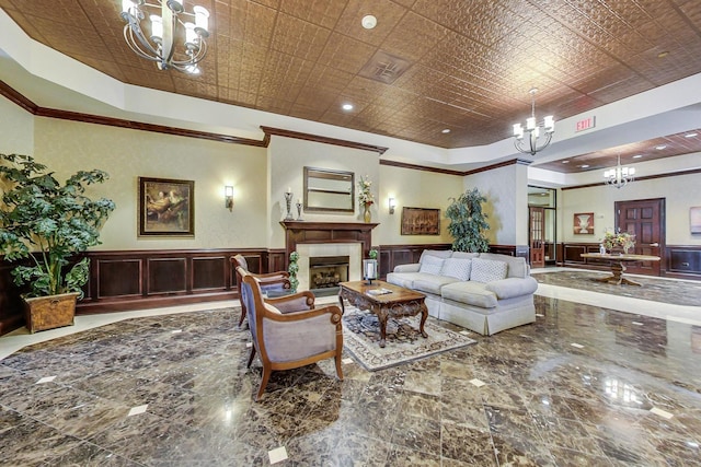 living room featuring crown molding, a chandelier, and a raised ceiling