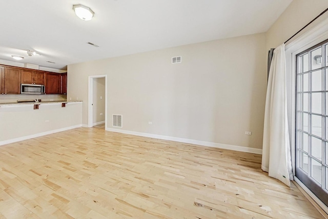 unfurnished living room featuring light wood-type flooring