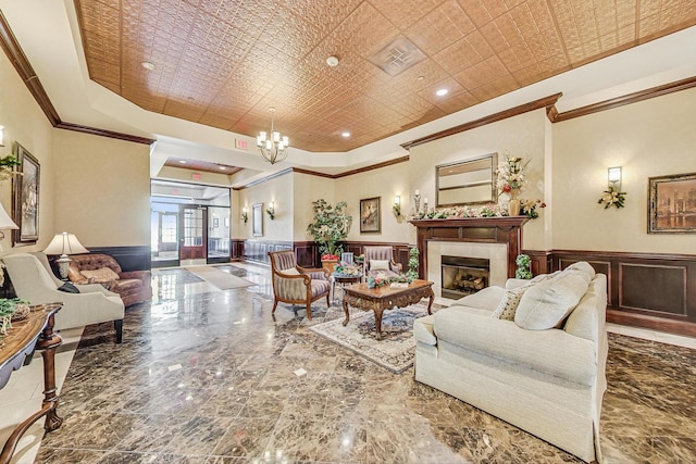 living room featuring crown molding, a raised ceiling, and a chandelier