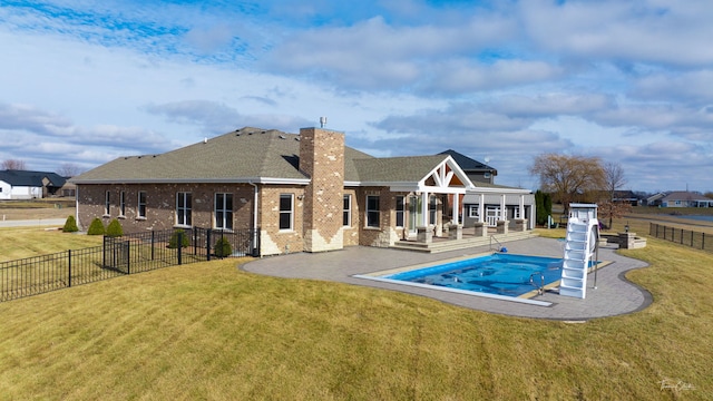 back of property featuring a lawn, a patio, and a covered pool