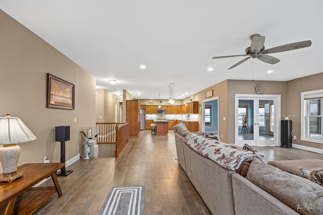 living room with hardwood / wood-style floors, french doors, and ceiling fan