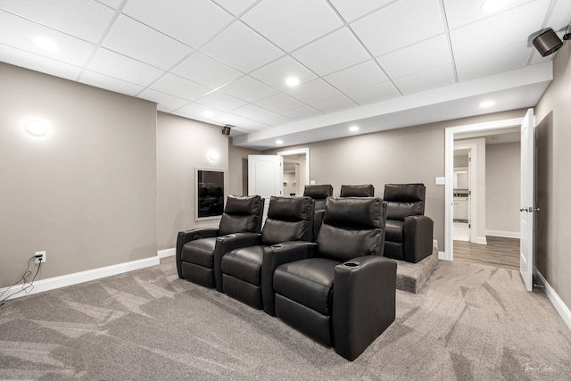 carpeted cinema room featuring a paneled ceiling