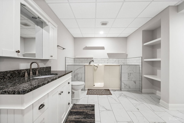 bathroom featuring a paneled ceiling, vanity, and toilet