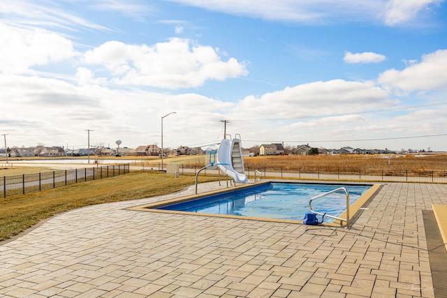 view of swimming pool featuring a yard, a water slide, and a patio area