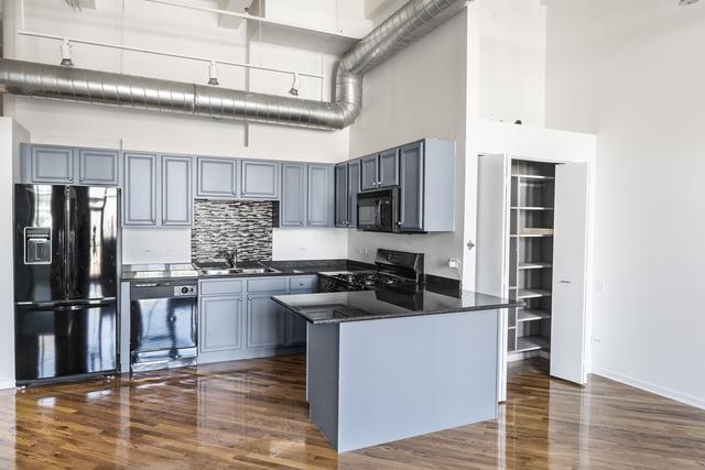 kitchen with dark countertops, a towering ceiling, a sink, a peninsula, and black appliances