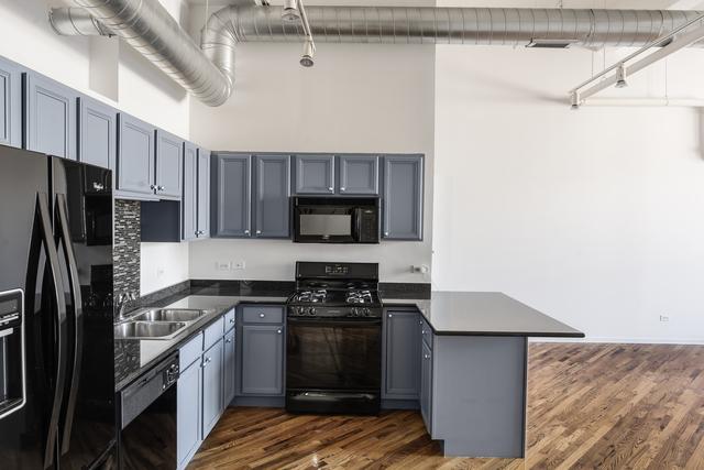 kitchen featuring dark countertops, gray cabinetry, a sink, a peninsula, and black appliances