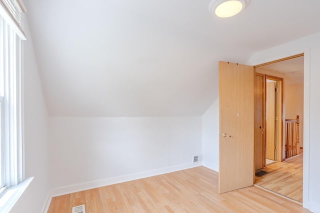 bonus room with lofted ceiling and light hardwood / wood-style flooring