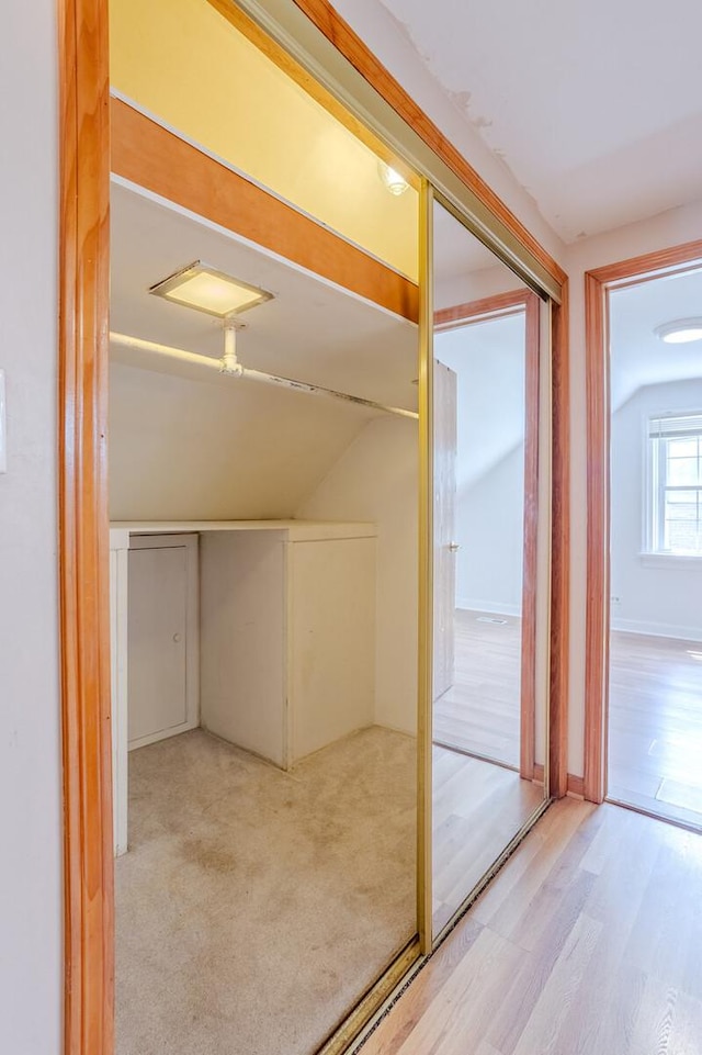 interior space featuring lofted ceiling and light hardwood / wood-style floors