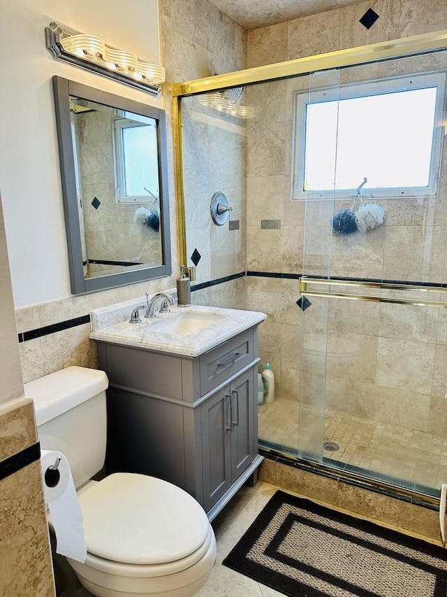 bathroom with walk in shower, vanity, toilet, and tile walls