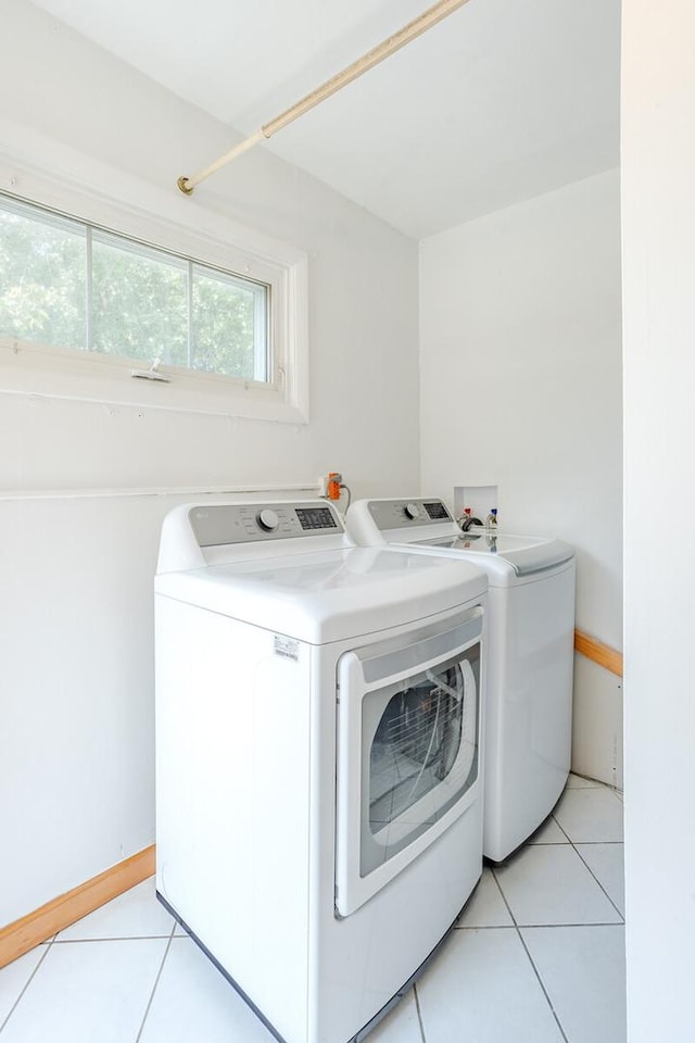 washroom featuring light tile patterned floors and washer and clothes dryer