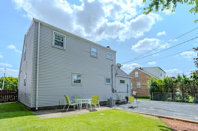 back of house with a lawn, a patio, and central air condition unit