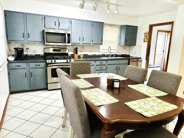 kitchen featuring backsplash, stainless steel appliances, sink, and light tile patterned floors