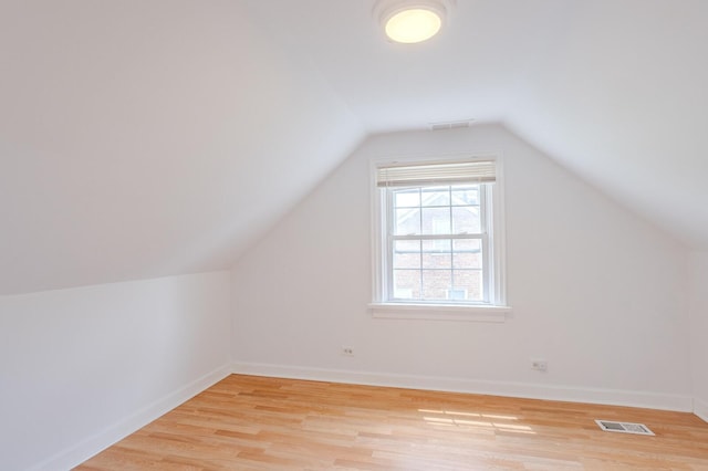 bonus room with vaulted ceiling and light wood-type flooring