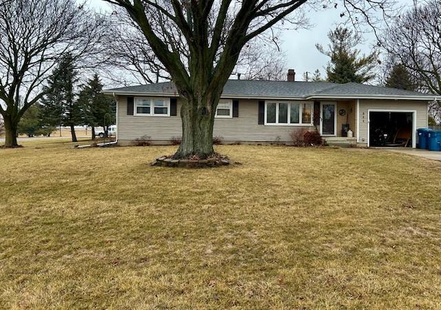 single story home with a garage and a front lawn