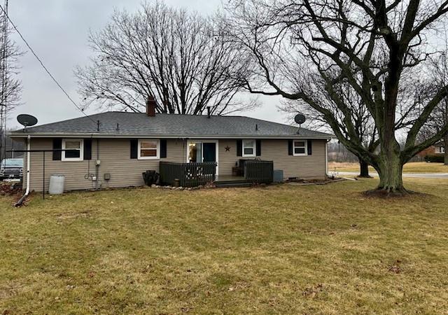 back of property featuring a wooden deck, central AC, and a lawn