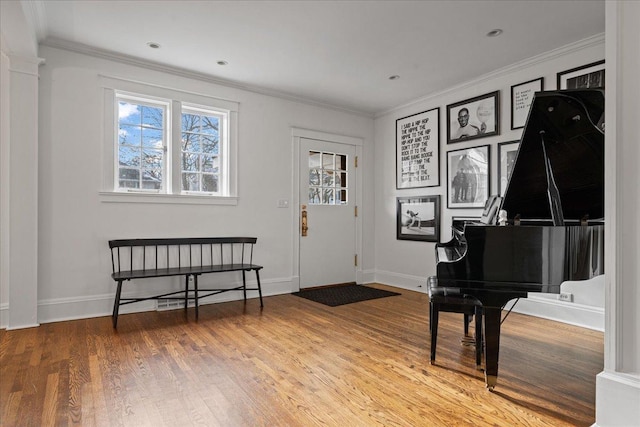 entryway with crown molding, baseboards, and wood finished floors