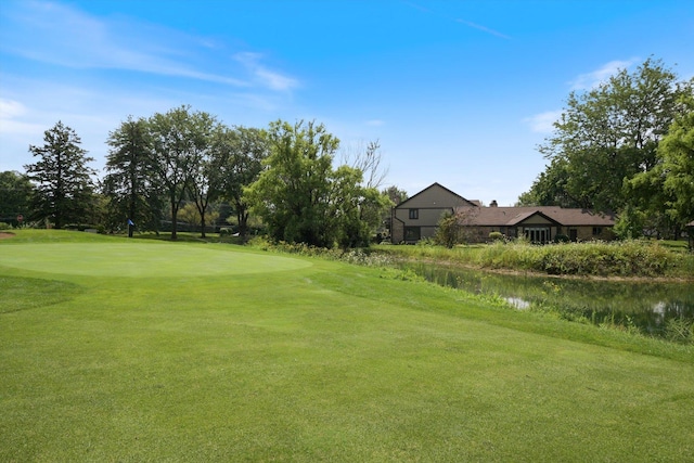 view of property's community with a lawn and a water view