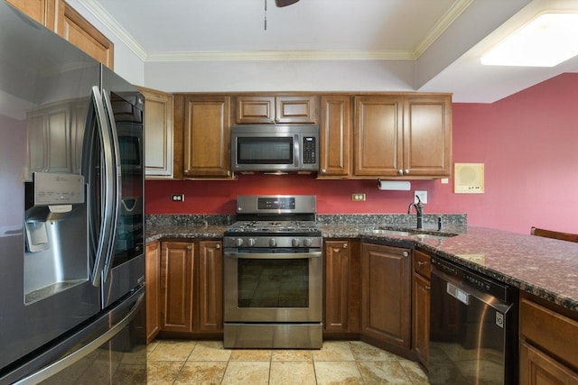 kitchen with crown molding, appliances with stainless steel finishes, sink, and dark stone counters