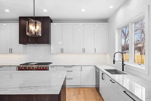 kitchen featuring sink, white cabinetry, hanging light fixtures, stainless steel appliances, and light stone countertops