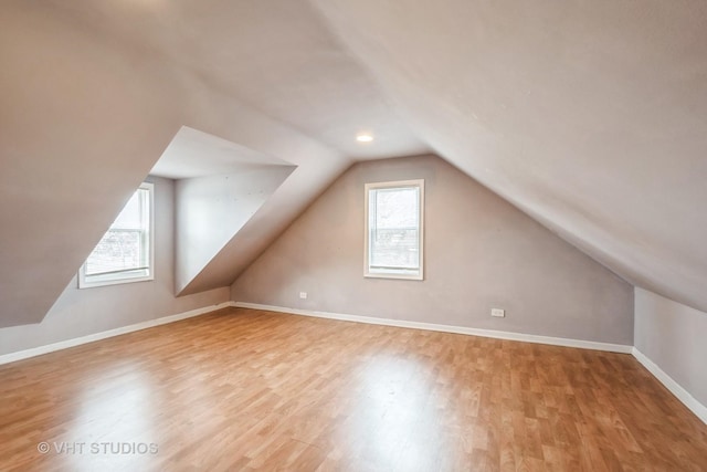 bonus room featuring a healthy amount of sunlight, vaulted ceiling, and light wood-type flooring