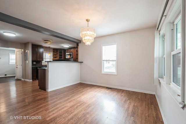 kitchen with pendant lighting, a notable chandelier, dark hardwood / wood-style flooring, and a healthy amount of sunlight