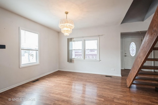 entrance foyer featuring dark hardwood / wood-style floors and a notable chandelier